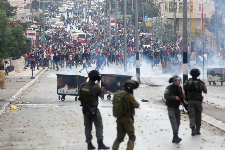 סערה: חיילים צולמו "נמלטים" מאימת פורעים ערביים בכפר קדום התפרעויות. אילוסטרציה
